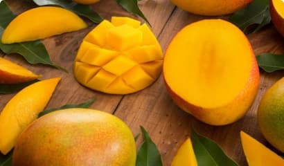 Несколько манго в различном виде на доске красиво оформлены с листьями